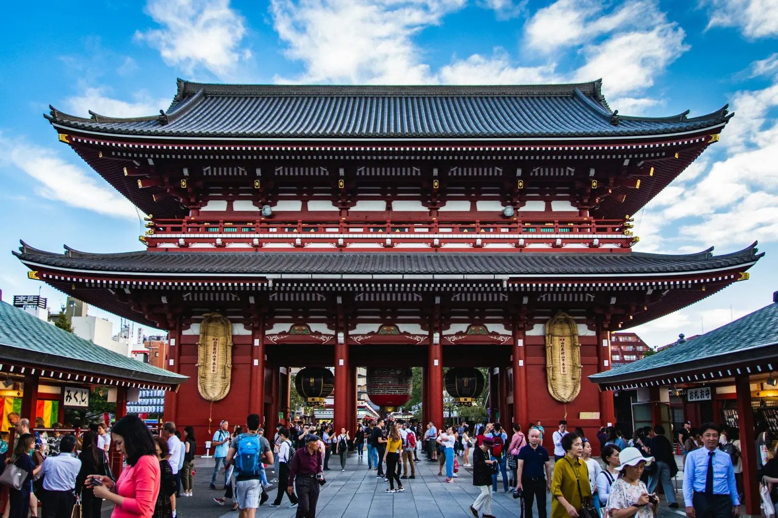 People walking towards Senso-ji's red gate on a bright morning in Asakusa